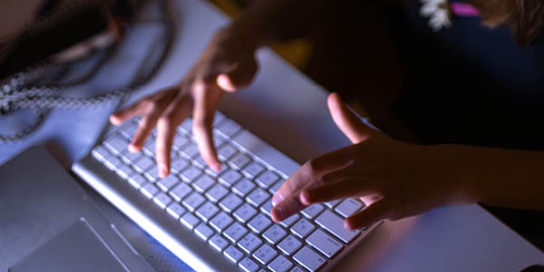 Two young girls at the computer at night. High quality photo