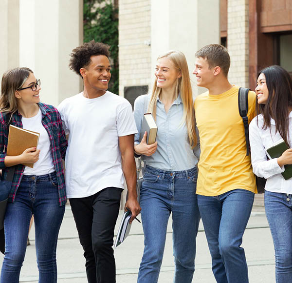 College classmates walking outside in campus, talking about exams