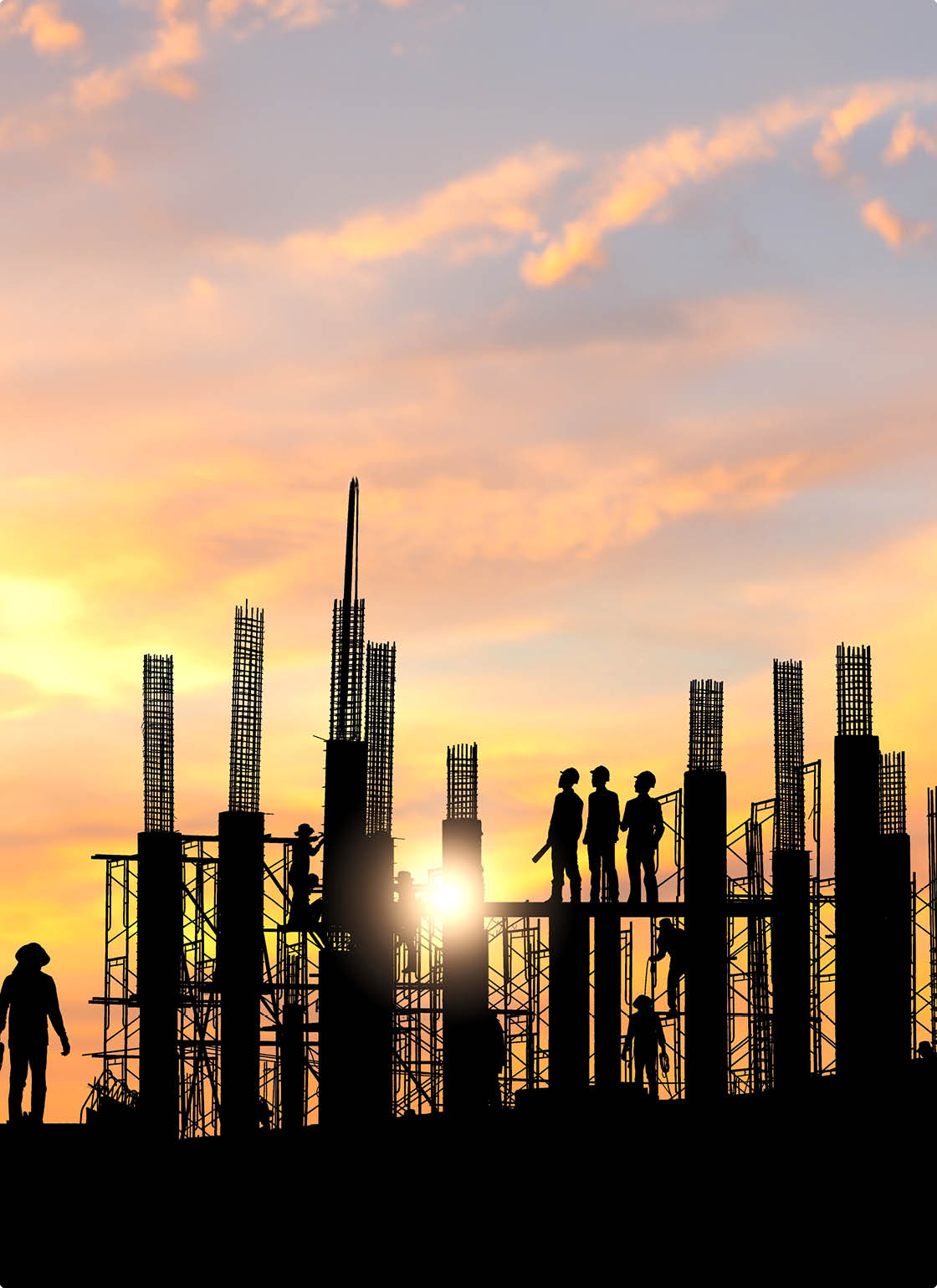 Silhouette of Engineer and worker checking project at building site background, construction site at sunset in evening time