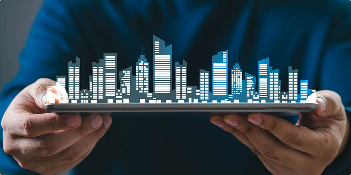 Hand holding a digital tablet with a virtual city skyline hologram. Concept of real estate, smart city, and modern urban technology.
