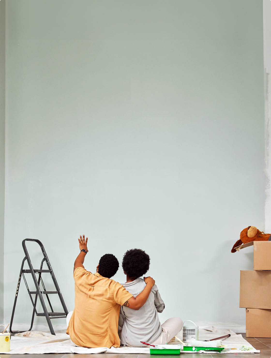 Planning, wall or black couple pointing in home renovation, diy or house remodel together on floor. Back view, painting or African man loves talking or working with teamwork in decoration with woman